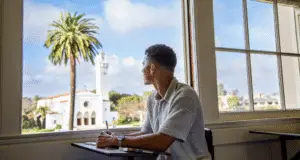 LMU student looking out the window at Sacred Heart chapel and Sunken Garden